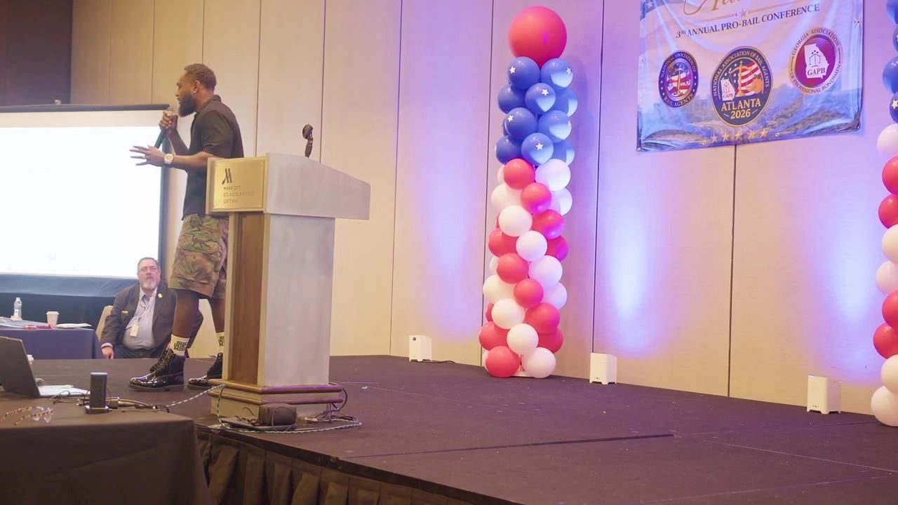 Tank at the podium at a conference